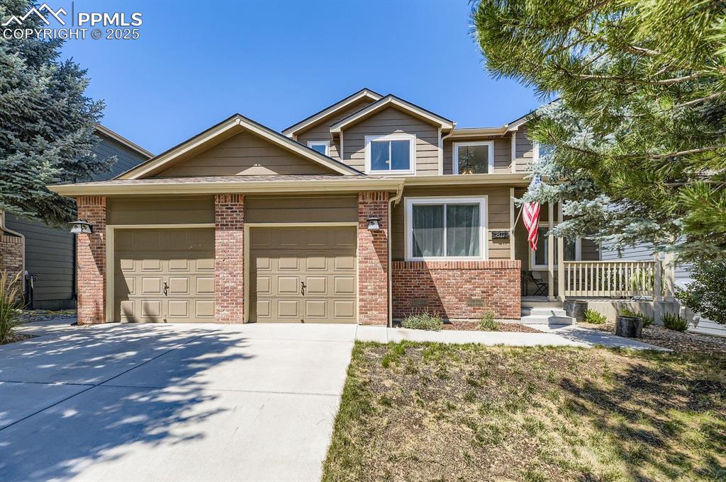 Image 1 of 32: View of front facade featuring brick siding, a garage, and driveway