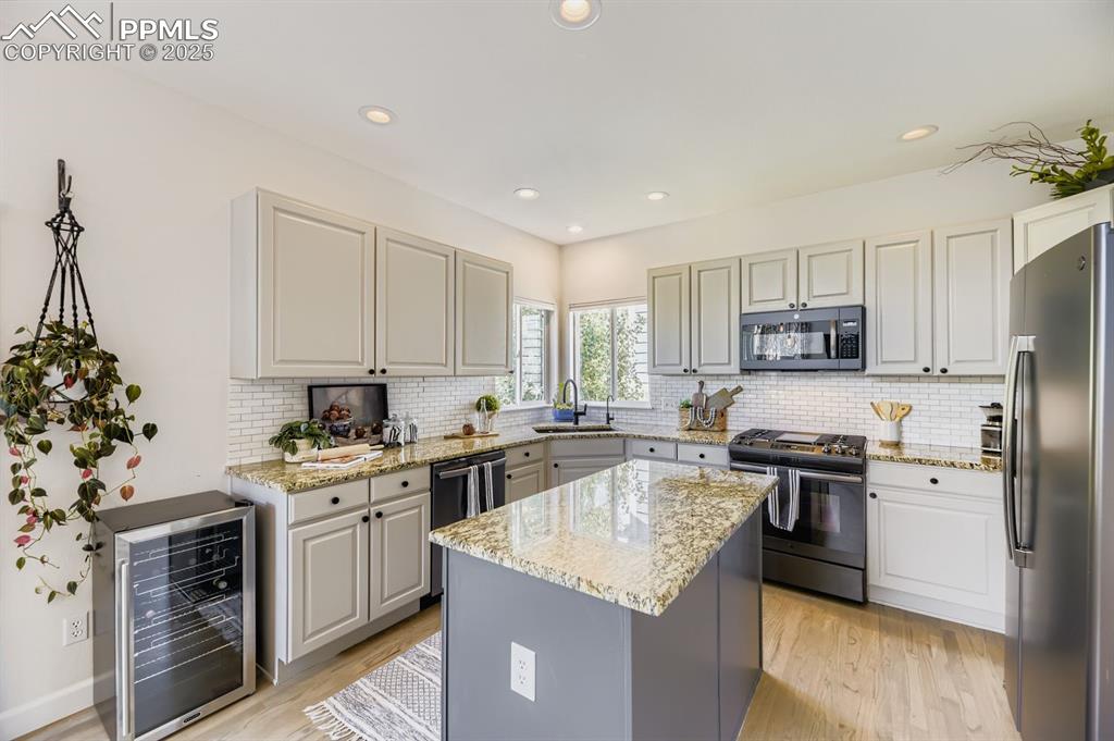 Image 11 of 32: Kitchen featuring gray cabinetry, appliances with stainless steel finishes,