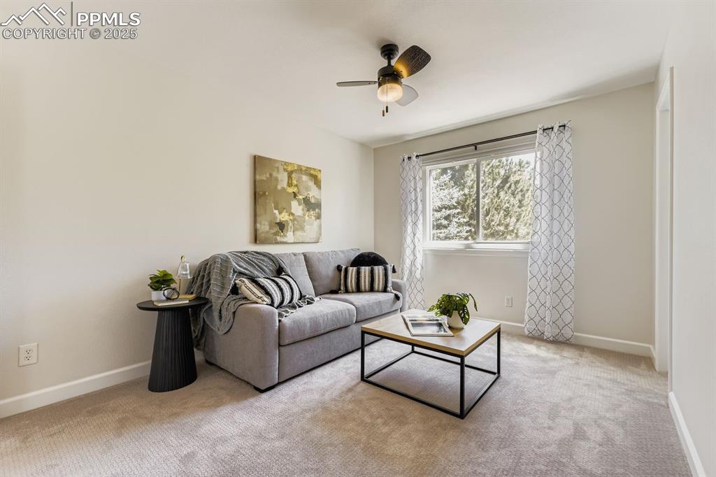 Image 16 of 32: Bedroom with light colored carpet and a ceiling fan