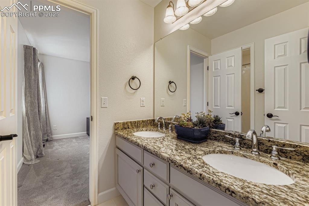 Image 17 of 32: Bathroom featuring double vanity and a shower with curtain