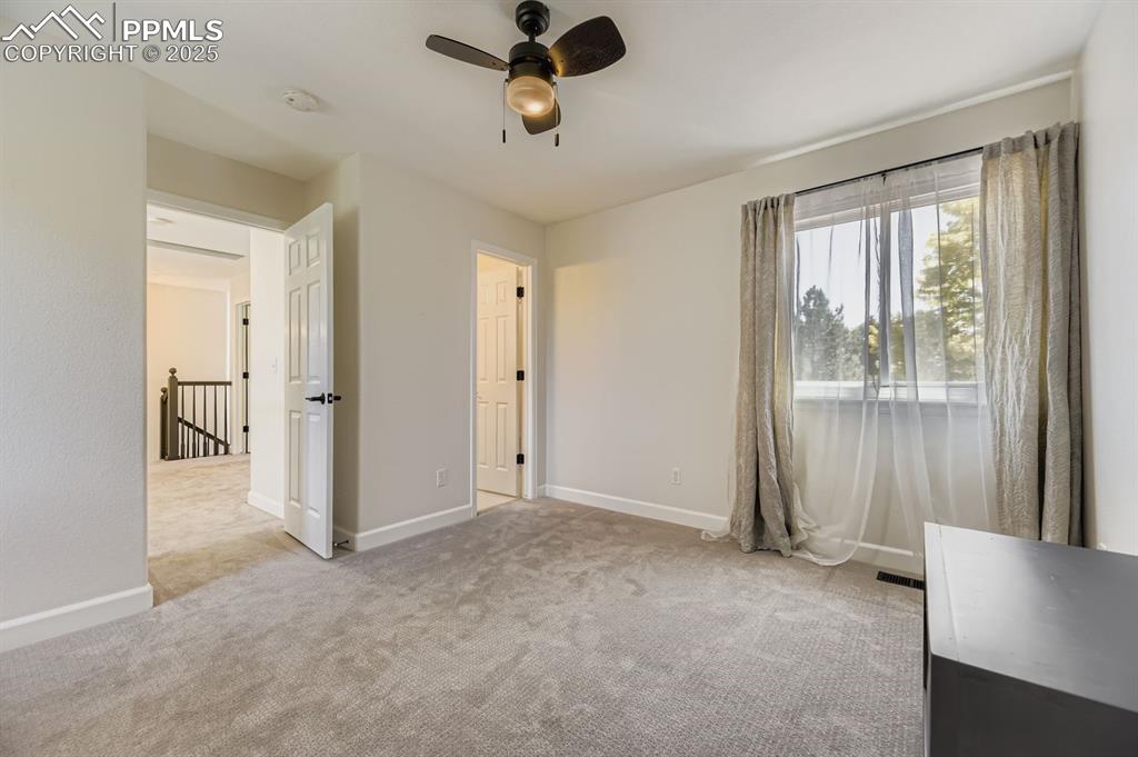 Image 18 of 32: Unfurnished bedroom with light carpet and ceiling fan