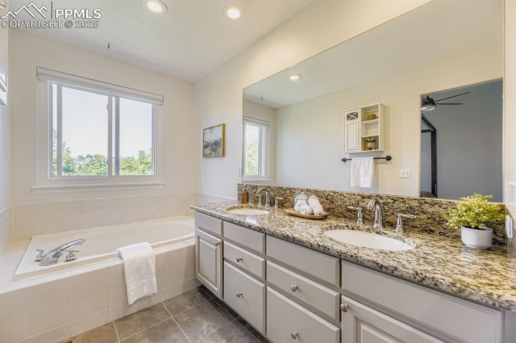 Image 21 of 32: Full bath featuring recessed lighting, a bath, double vanity, and light til