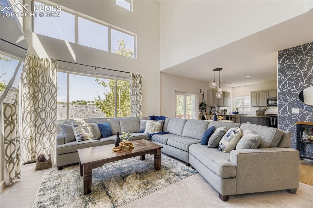 Image 3 of 32: Carpeted living room featuring a towering ceiling