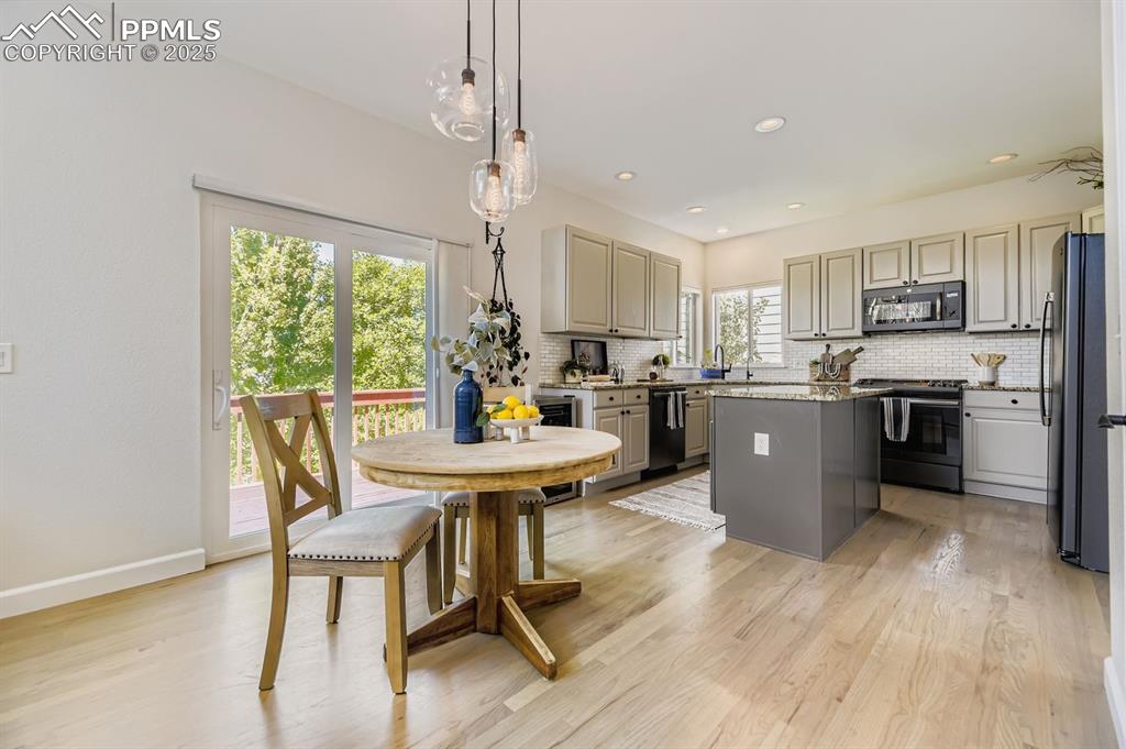 Image 4 of 32: Kitchen with gray cabinets, backsplash, hanging light fixtures, gas range, 
