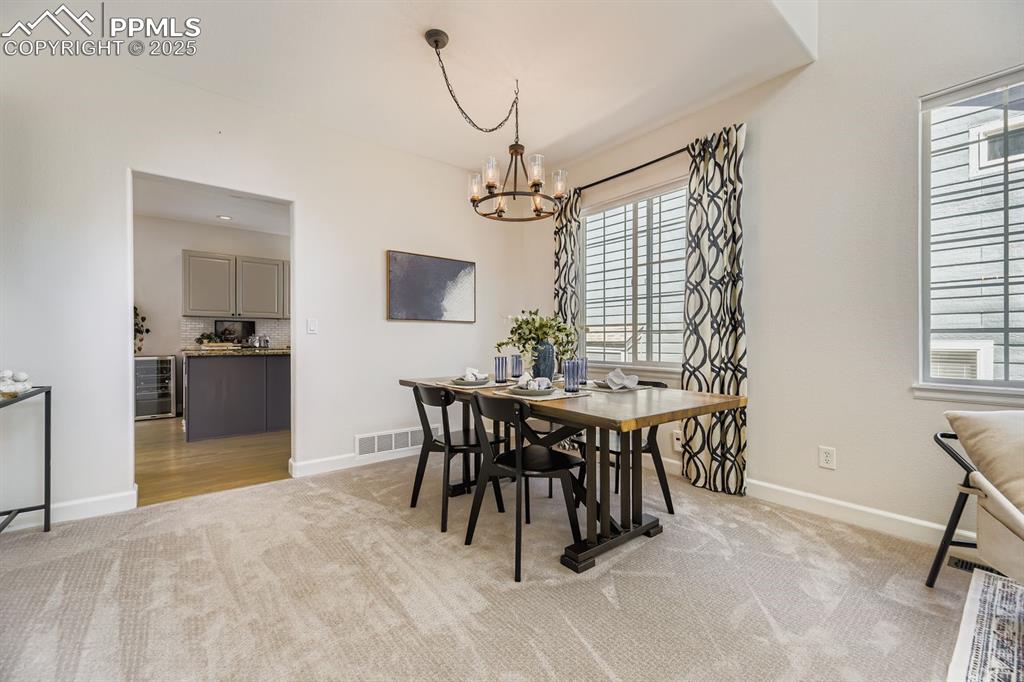 Image 8 of 32: Dining space featuring light colored carpet and a chandelier
