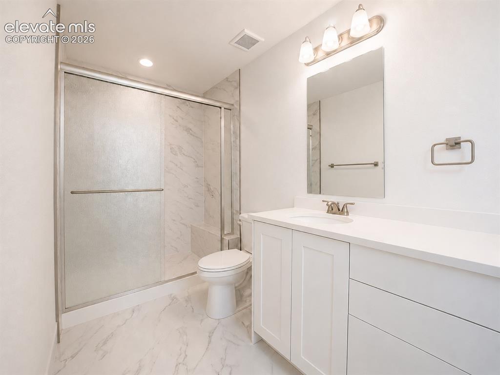 Image 11 of 19: Modern bathroom featuring a white vanity with integrated sink, a rectangula