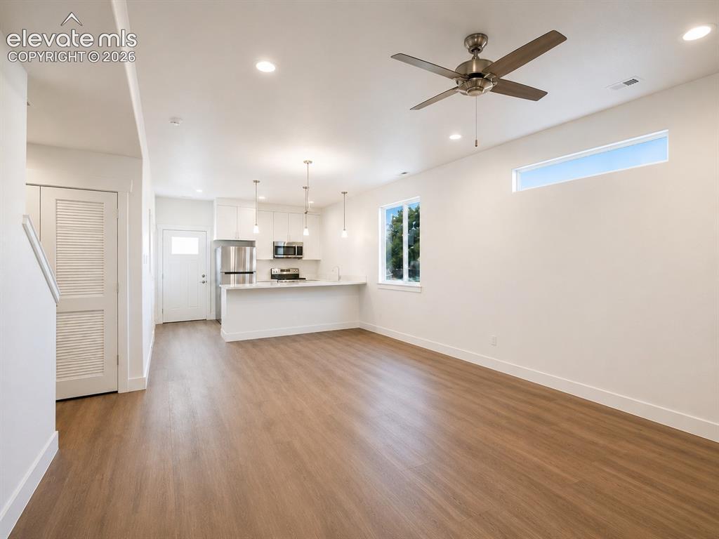 Image 5 of 19: Open-concept living space featuring wood-finish flooring, recessed lighting