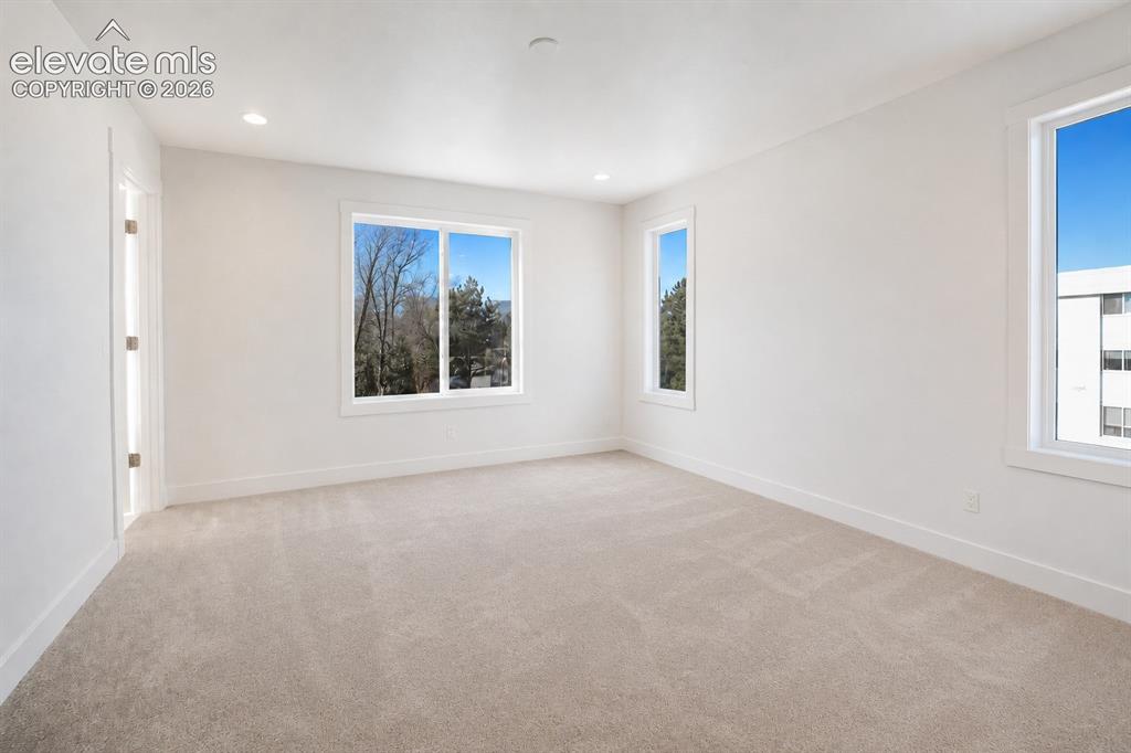 Image 9 of 19: Spacious interior featuring a neutral carpet, white walls, and multiple lar