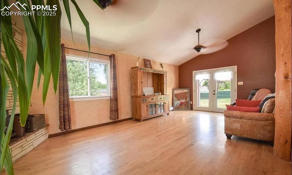 Image 6 of 23: Living room featuring french doors, wood finished floors, lofted ceiling, a