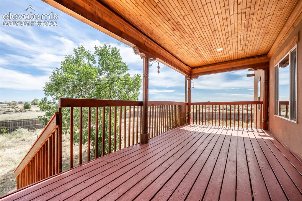 Image 37 of 50: Beautifully covered back deck with fresh paint.