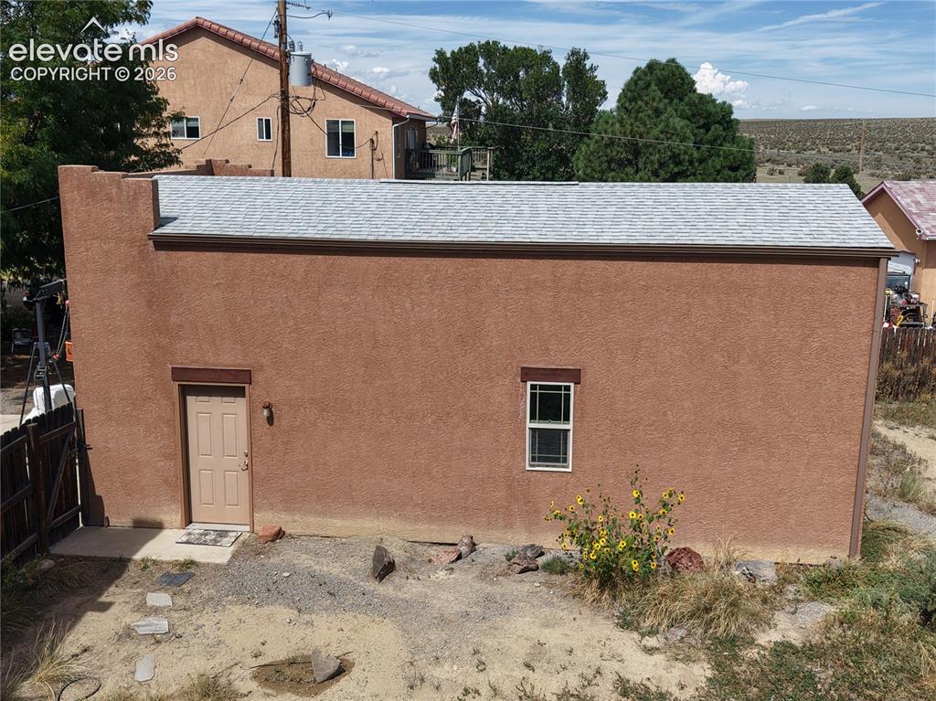 Image 42 of 50: Side of RV Garage, Art studio or Workshop.   Fresh stucco and roof are new.