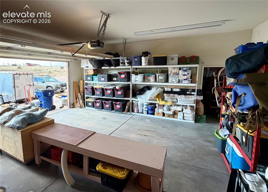 Image 45 of 50: 3 car garage with room for lots of storage and tall ceilings.