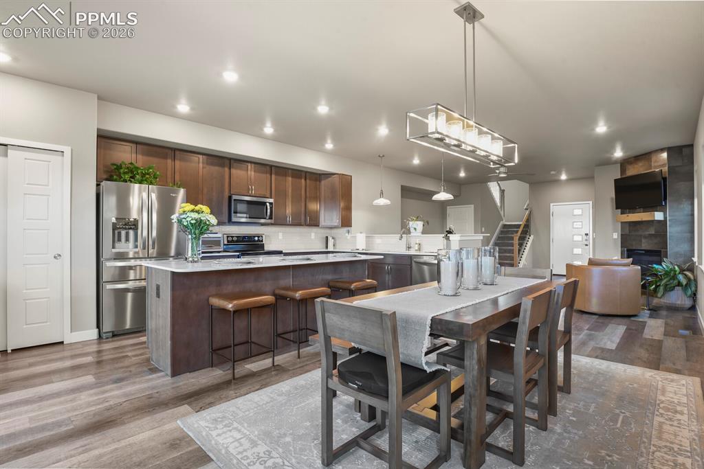Image 11 of 33: Open concept living space featuring wood-finish flooring, recessed lighting