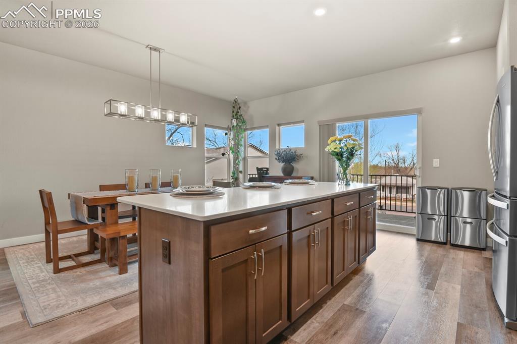 Image 13 of 33: Contemporary kitchen island featuring a light-toned countertop and rich woo