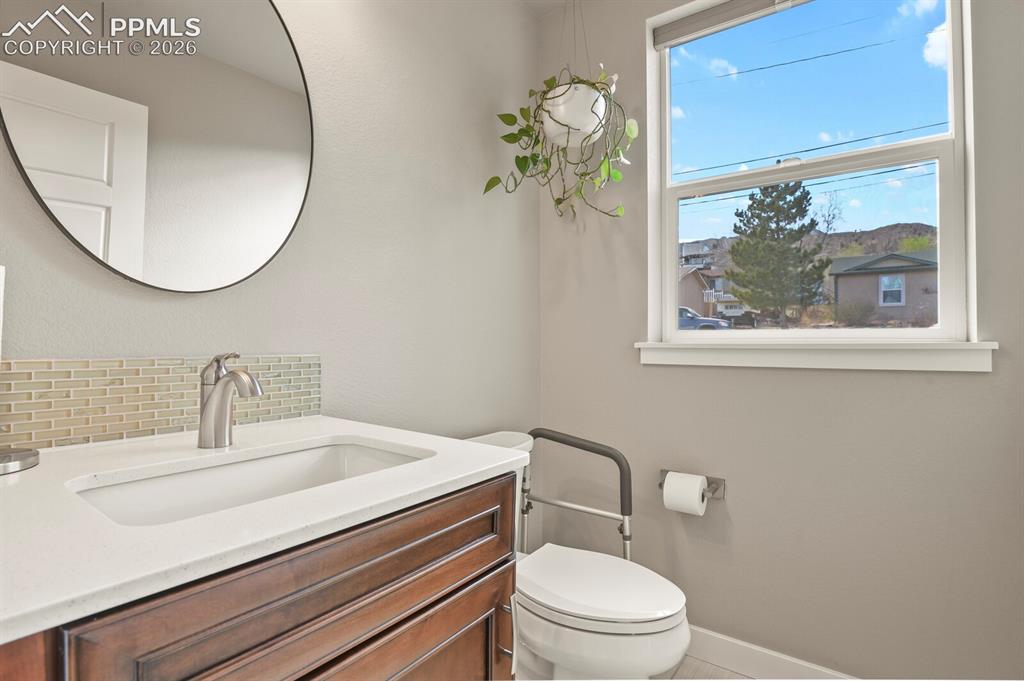 Image 16 of 33: Bathroom featuring a wood-finish vanity with a built-in rectangular sink, w