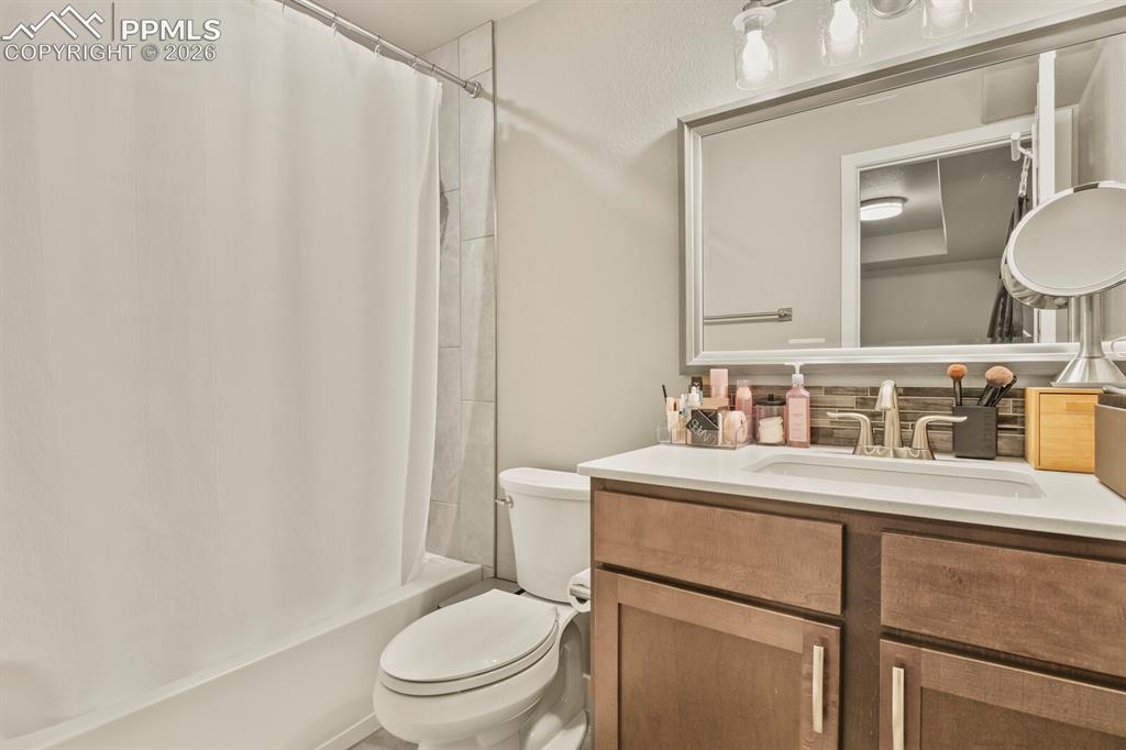 Image 18 of 33: Bathroom featuring a wood-finish vanity with a white countertop and integra