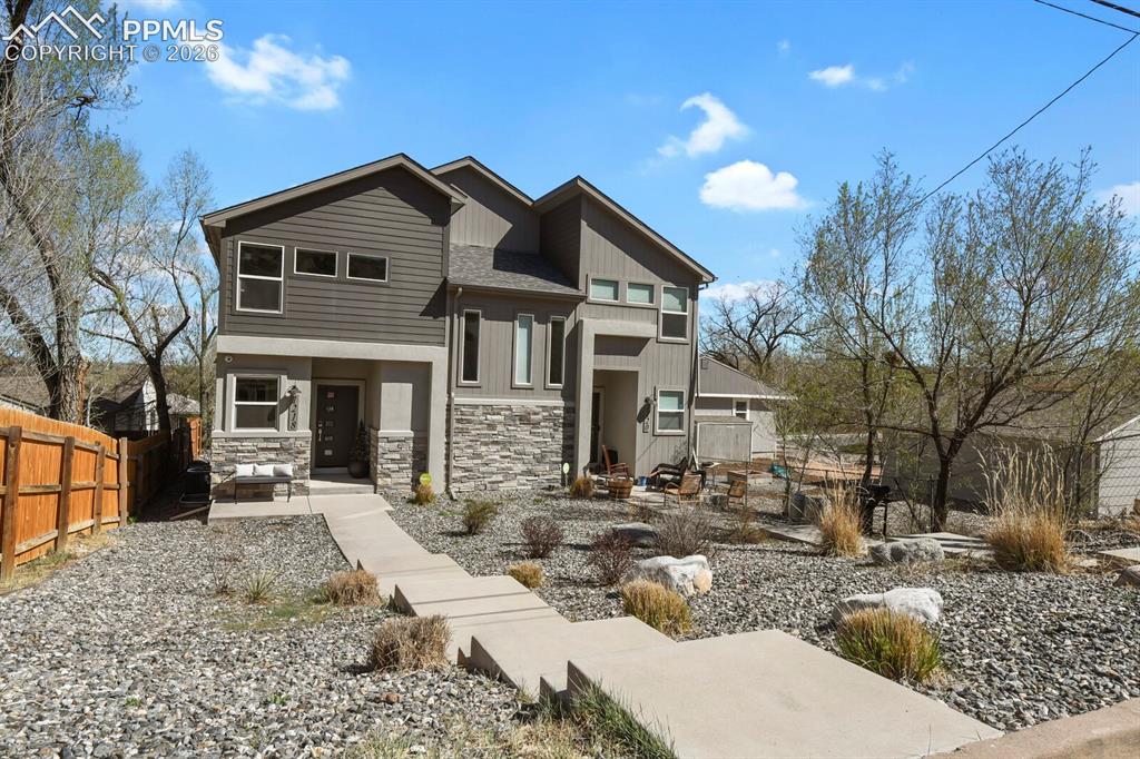Image 2 of 33: Modern facade featuring horizontal siding and stone accents