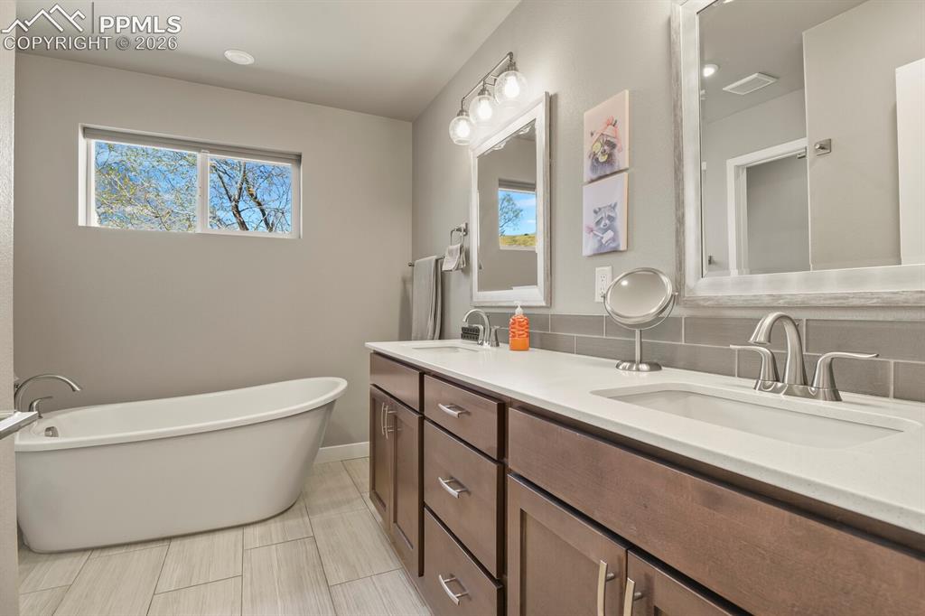Image 22 of 33: Bathroom featuring a freestanding soaking tub, dual vanity with undermount 