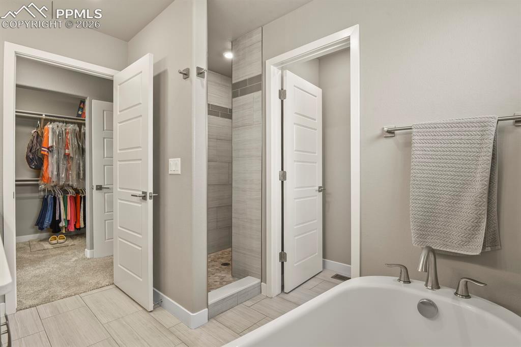 Image 23 of 33: Bathroom featuring a built-in soaking tub with brushed nickel fixtures, a t