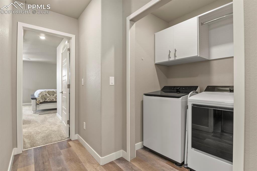 Image 28 of 33: Dedicated laundry area featuring upper white cabinetry, a built-in hanging 