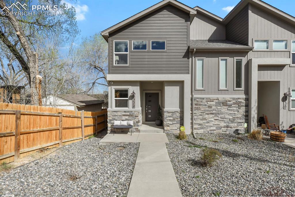 Image 3 of 33: Contemporary multi-level residence featuring a gray siding and stone veneer