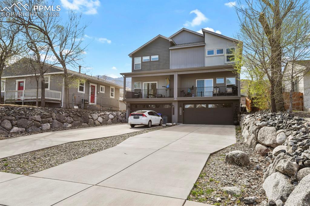 Image 30 of 33: Contemporary multi-story residence featuring a two-car garage, multiple bal