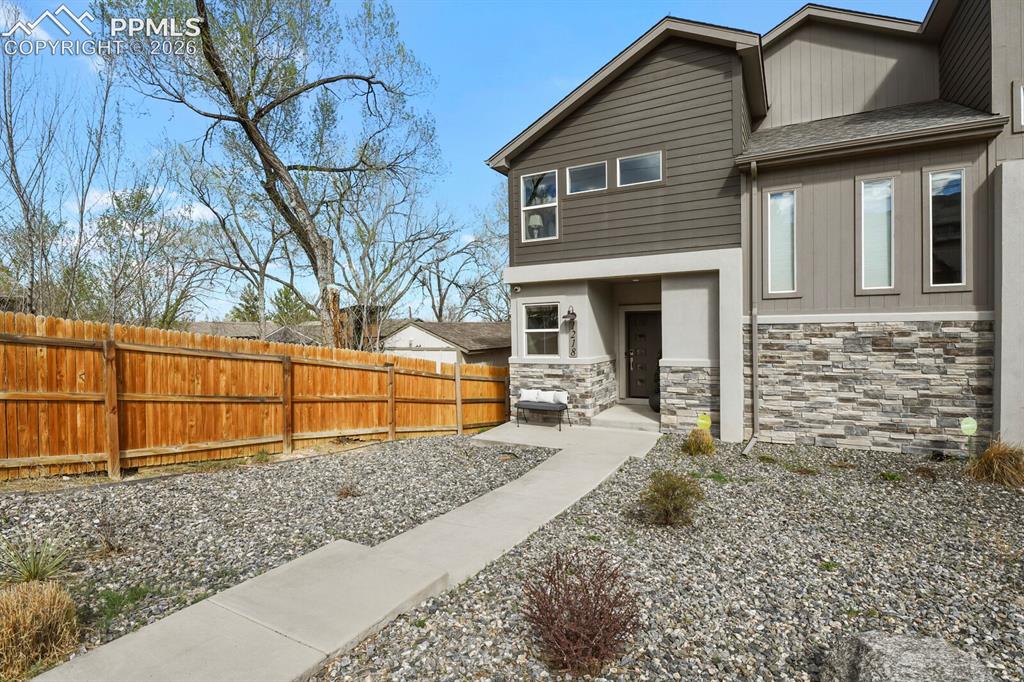 Image 4 of 33: Contemporary facade featuring stone veneer accents, horizontal siding, and 