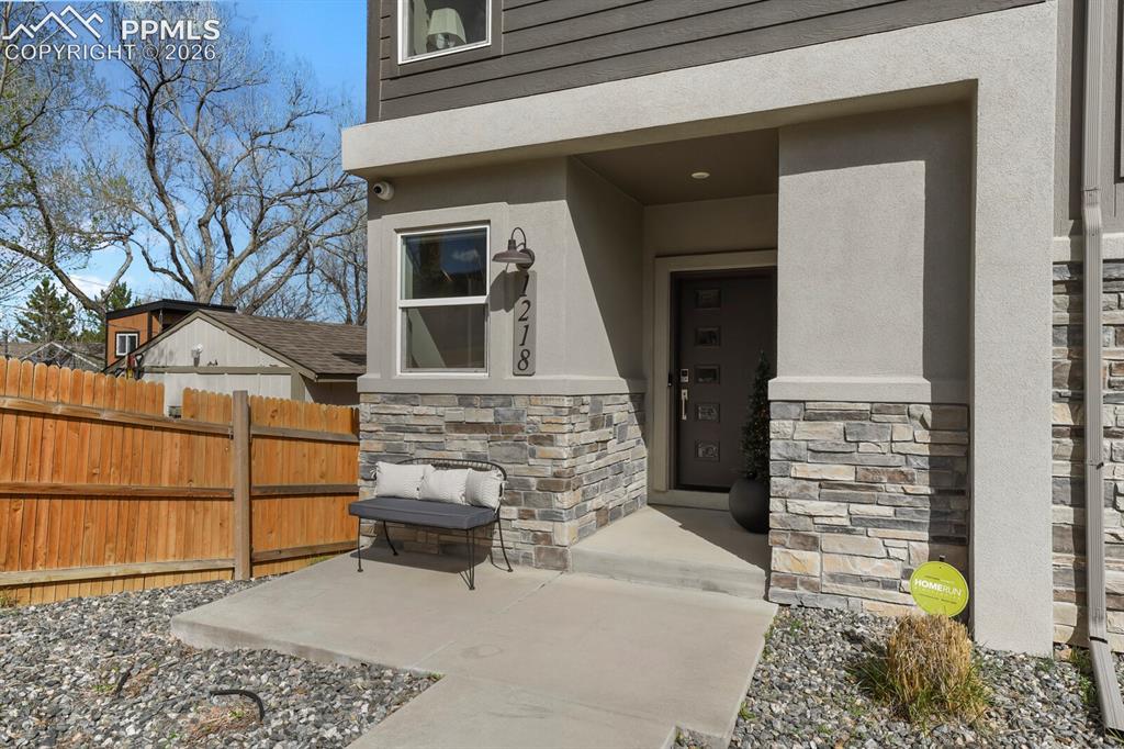 Image 5 of 33: Modern exterior featuring stacked stone accents, horizontal siding, a cover