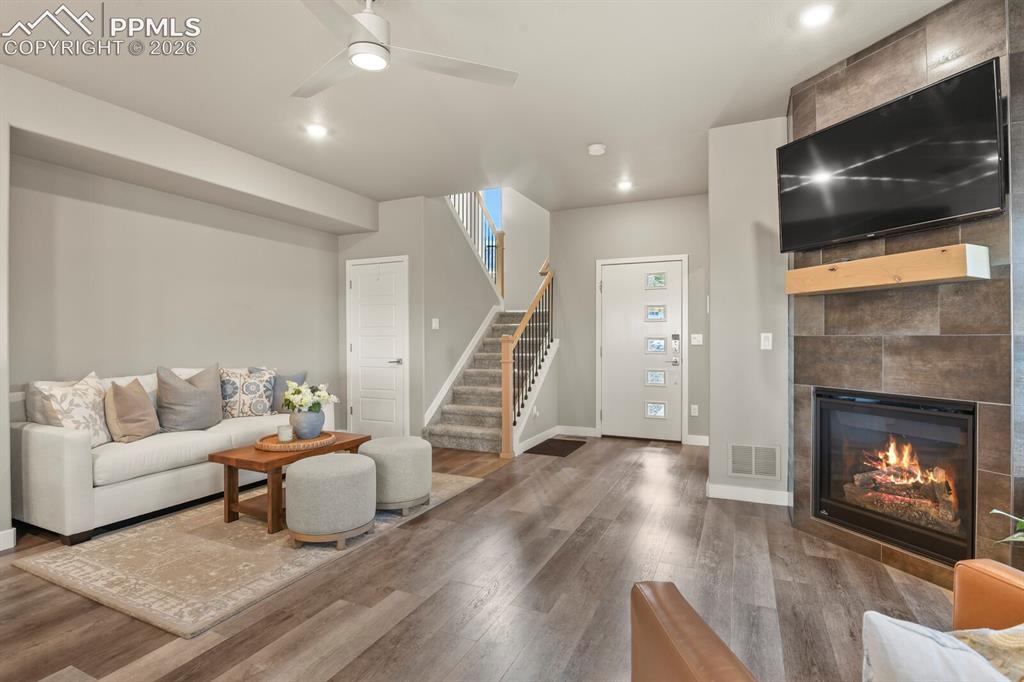 Image 8 of 33: Contemporary living area featuring wood-finish flooring, a modern ceiling f