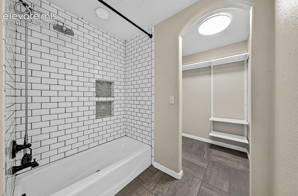 Image 18 of 36: Tub/shower with subway tile and niche