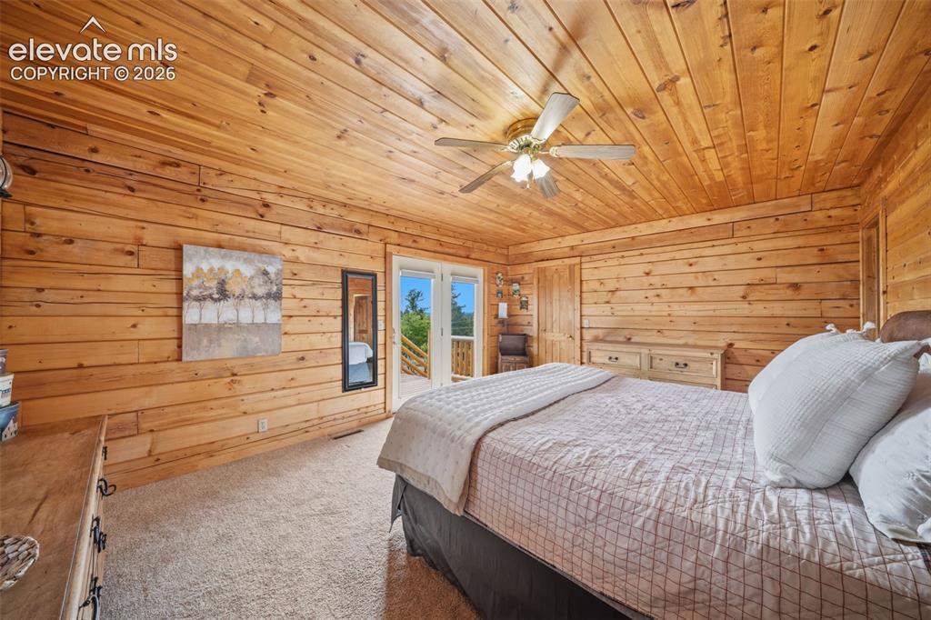 Image 12 of 39: Main level primary bedroom with walk out to deck, views, walk in closet, en
