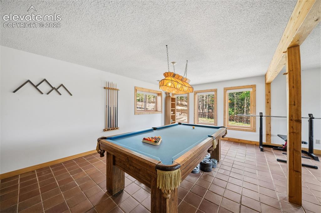 Image 17 of 39: Basement level game room area-pool table stays