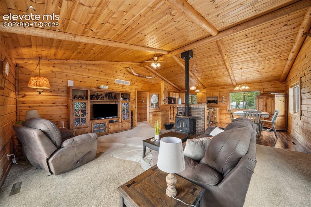 Image 6 of 39: Main level living room with vaulted wood ceilings, walls and open concept