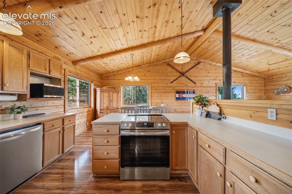 Image 9 of 39: Main level kitchen with tongue and groove ceilings and beams