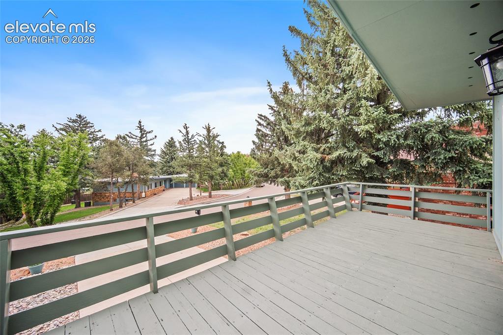 Image 17 of 50: Expansive outdoor deck with painted wood flooring and matching railings