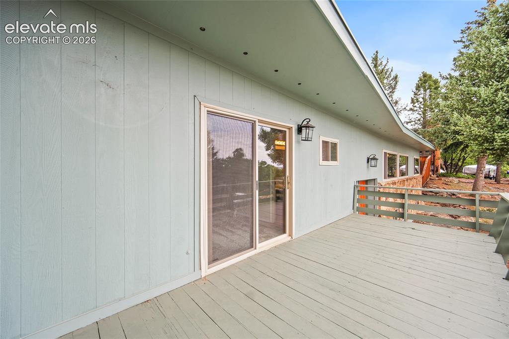 Image 18 of 50: Exterior deck with painted wood flooring and railing