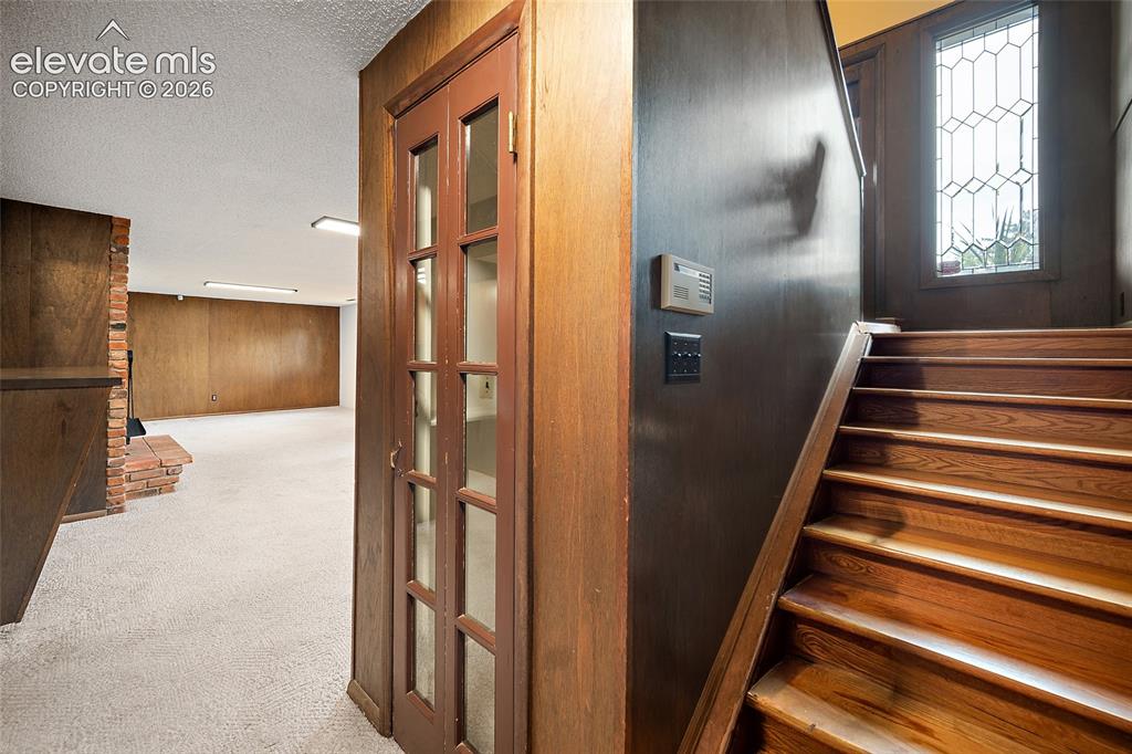 Image 26 of 50: Wood-finish staircase featuring a decorative leaded glass window