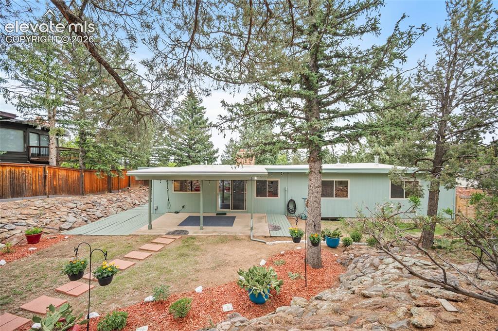 Image 36 of 50: Expansive backyard featuring a covered patio, sliding glass door access, ex