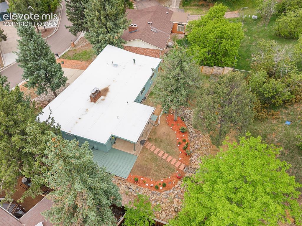 Image 43 of 50: Aerial perspective showcasing a light-colored roof, a red brick chimney, an
