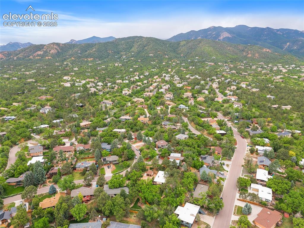 Image 47 of 50: Mountainous landscape featuring residential properties among mature trees a