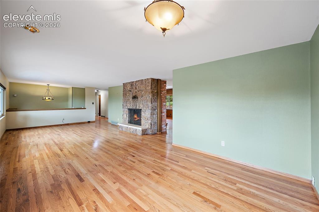 Image 5 of 50: Open concept living area featuring wood-finish flooring throughout, a stone