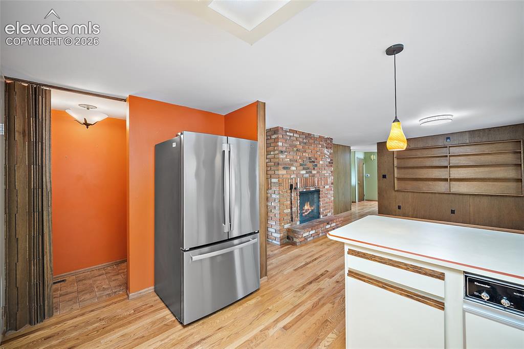 Image 8 of 50: Stainless steel French door refrigerator, wood-finish flooring, brick firep