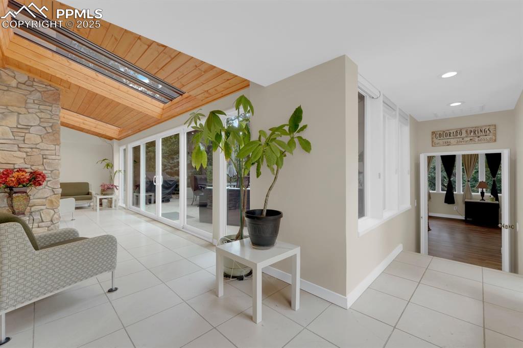 Image 16 of 43: Corridor featuring lofted ceiling, tile patterned floors, wood ceiling, and