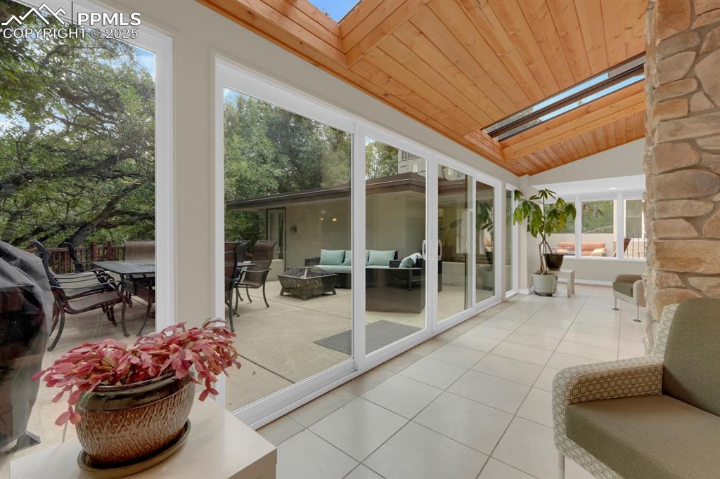 Image 3 of 43: Sunroom / solarium featuring a skylight, vaulted ceiling, wooden ceiling, a