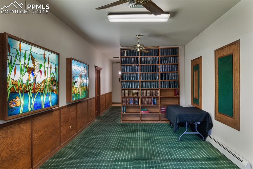 Image 16 of 31: Sitting room with a baseboard heating unit, carpet floors, a wainscoted wal