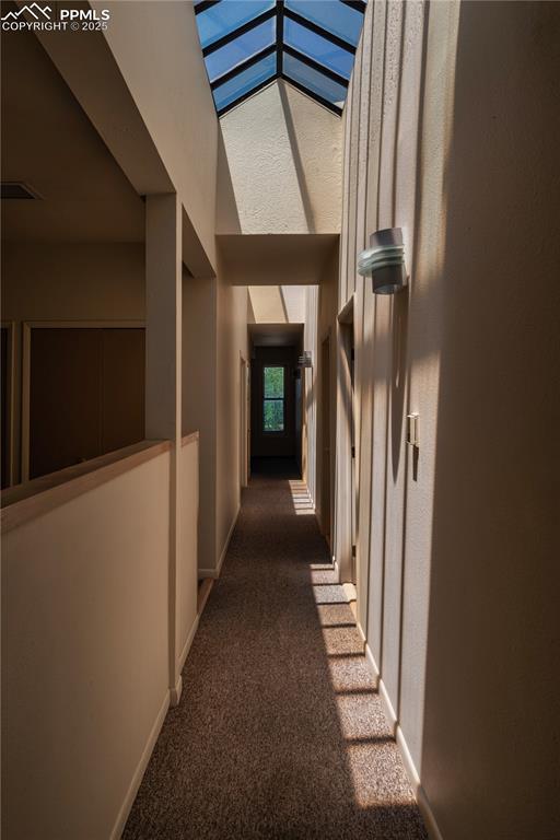 Image 8 of 31: Corridor with dark carpet and baseboards