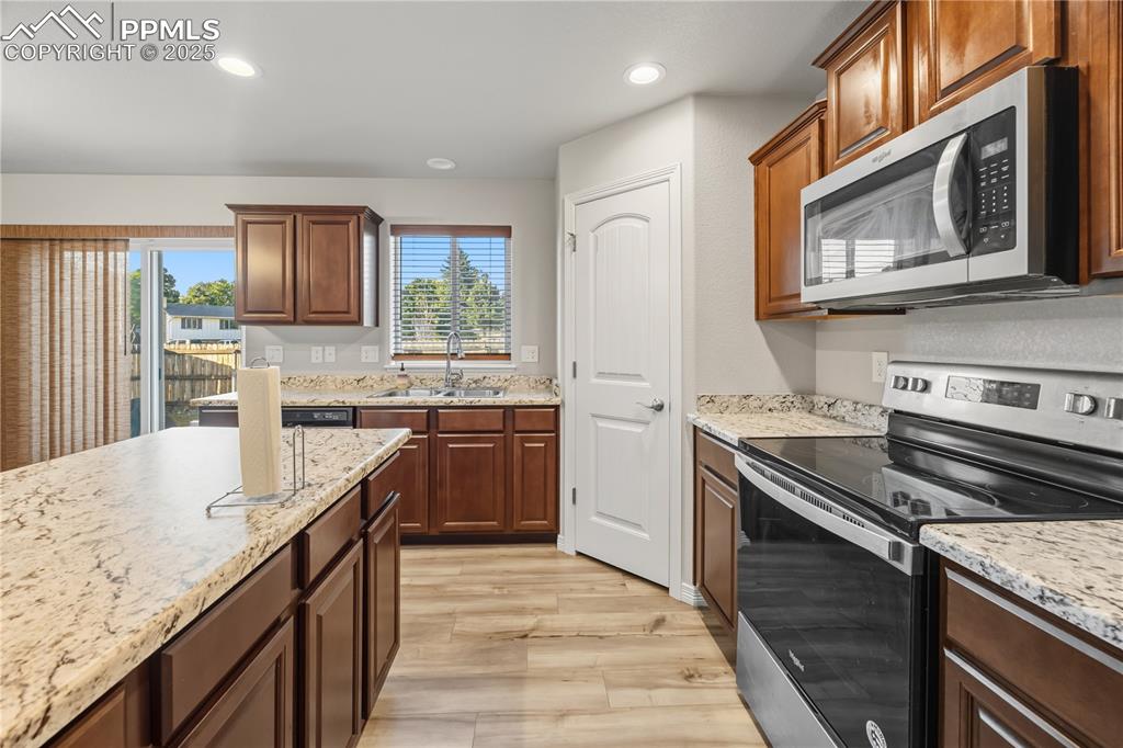 Image 14 of 33: Kitchen with stainless steel appliances, light wood finished floors, recess
