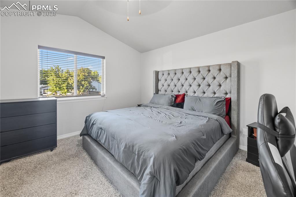 Image 16 of 33: Bedroom featuring vaulted ceiling, carpet floors, and ceiling fan