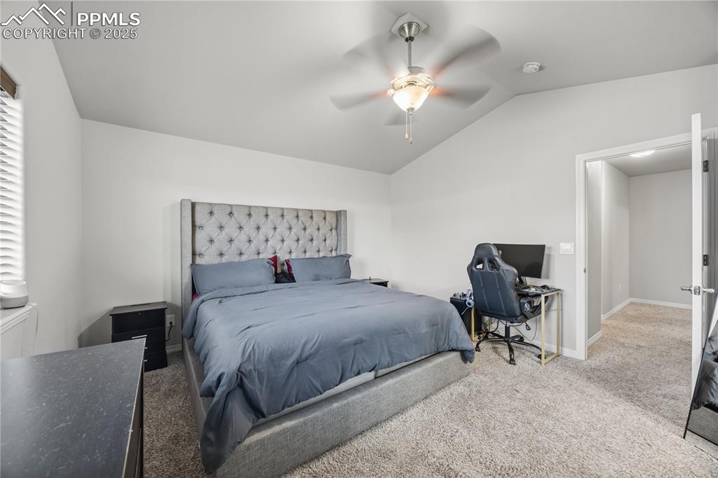 Image 17 of 33: Bedroom featuring carpet floors, vaulted ceiling, and ceiling fan