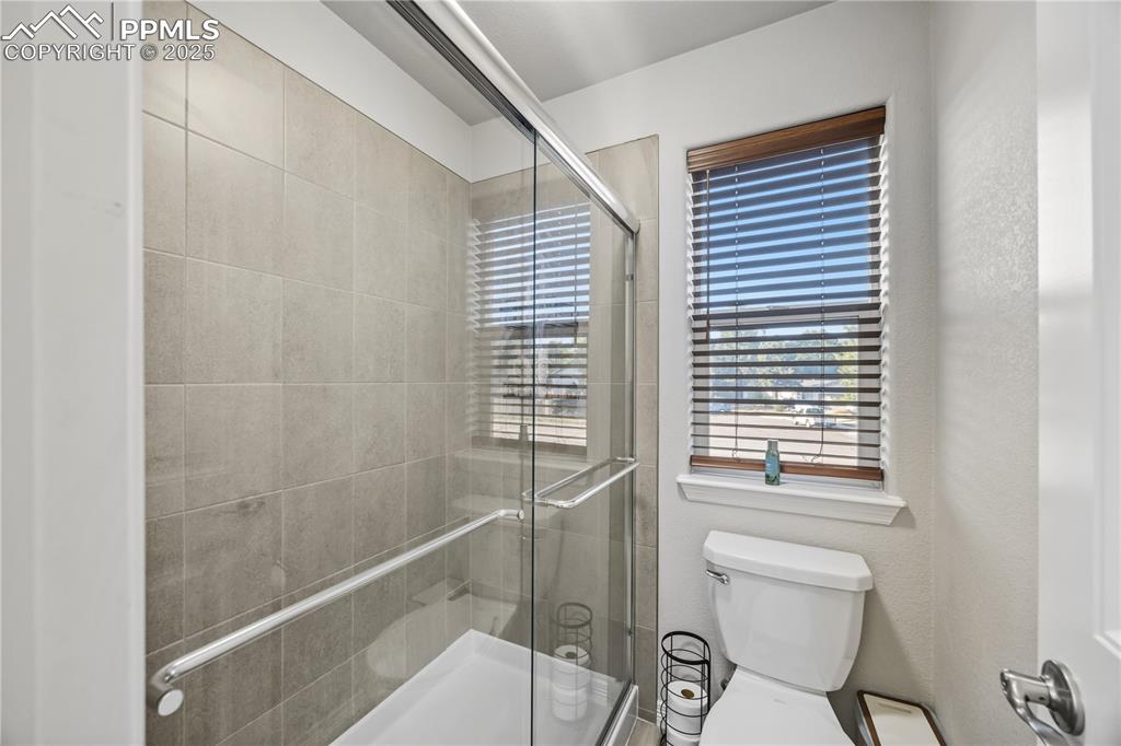Image 20 of 33: Bathroom with a shower stall and a textured wall